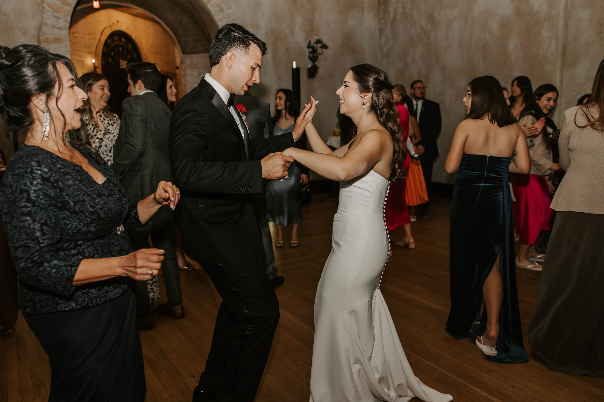 Bride and groom dancing with family at their reception